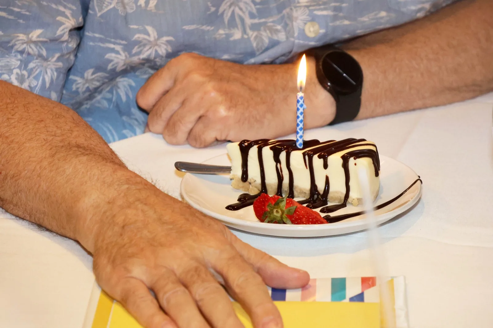 Slice of cheesecake with chocolate drizzle, strawberry, and a birthday candle at Sunday brunch at The Venue Clermont